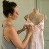 Designer fitting a bespoke lingerie prototype on a dress form in the atelier.