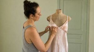 Designer fitting a bespoke lingerie prototype on a dress form in the atelier.
